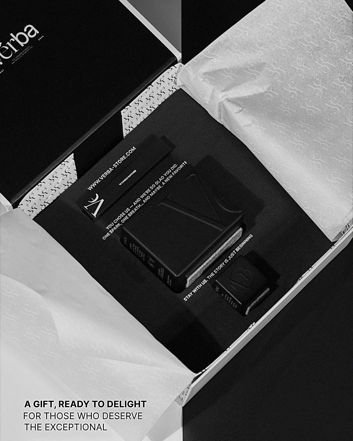 Verba black gift box opened to reveal a sculpted black candle and matches arranged in premium tissue wrapping.