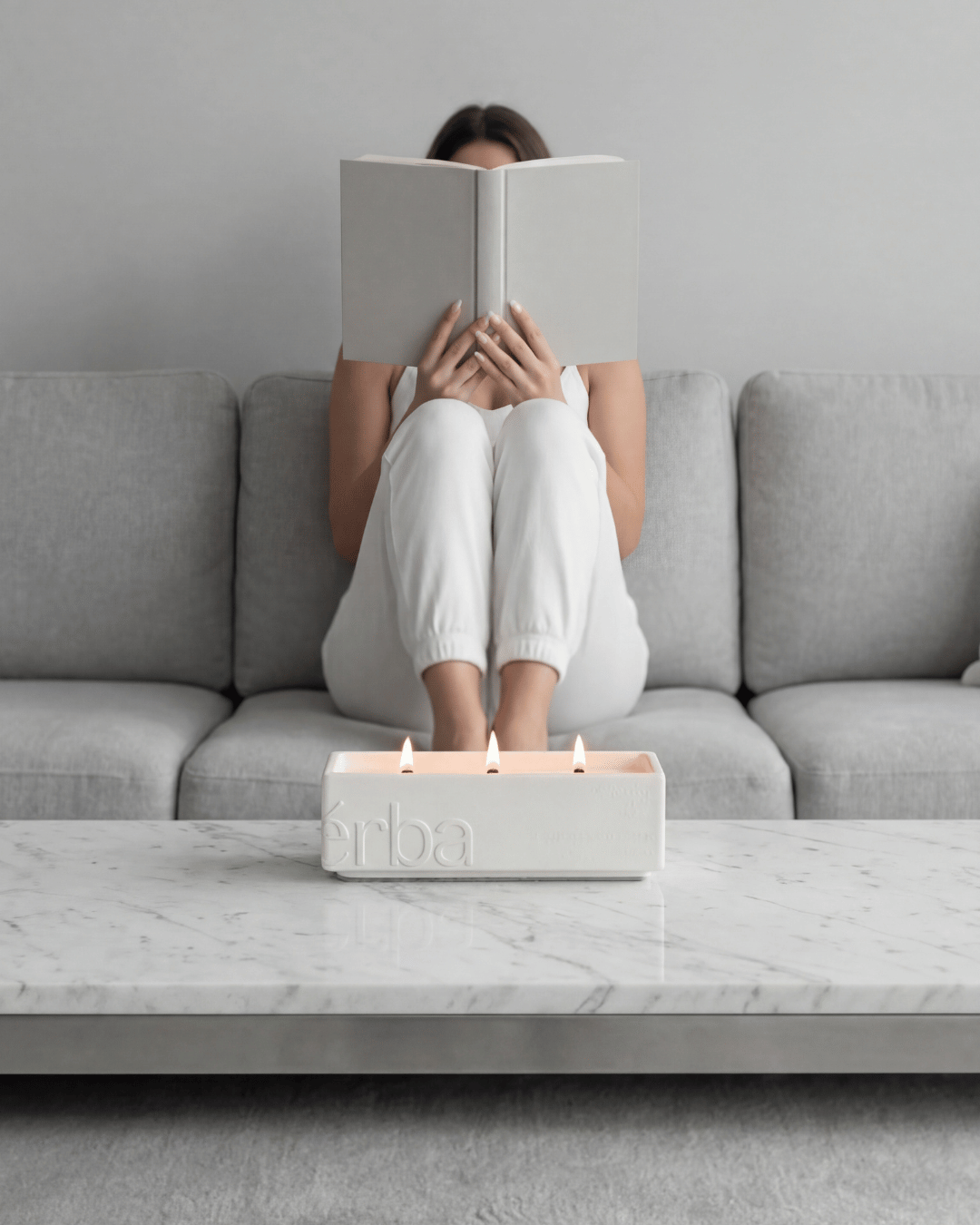 Woman read abook on couch with Verba large niche scented candle