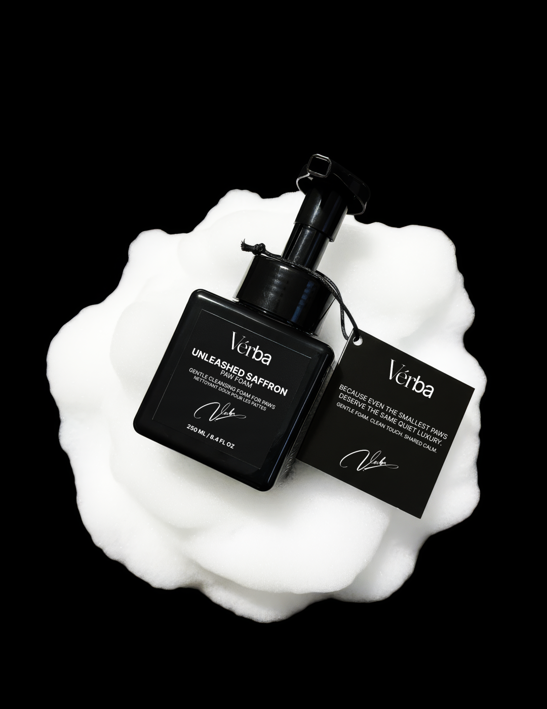 Black Verba Unleashed Saffron paw foam bottle resting on soft white foam — luxury pet cleanser from Verba.