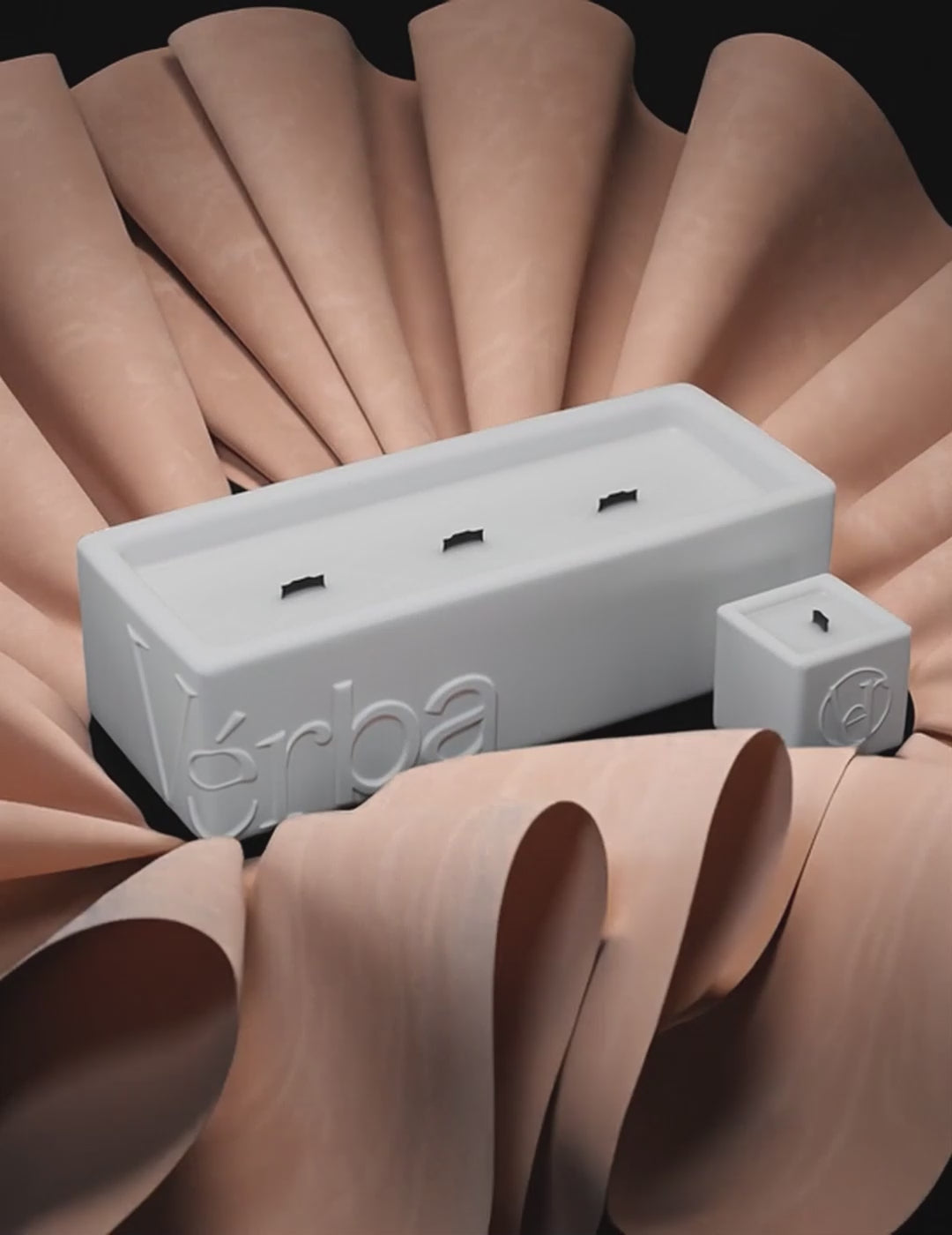 Large white Verba candle surrounded by folded beige leather — Soft Bound fragrance video.