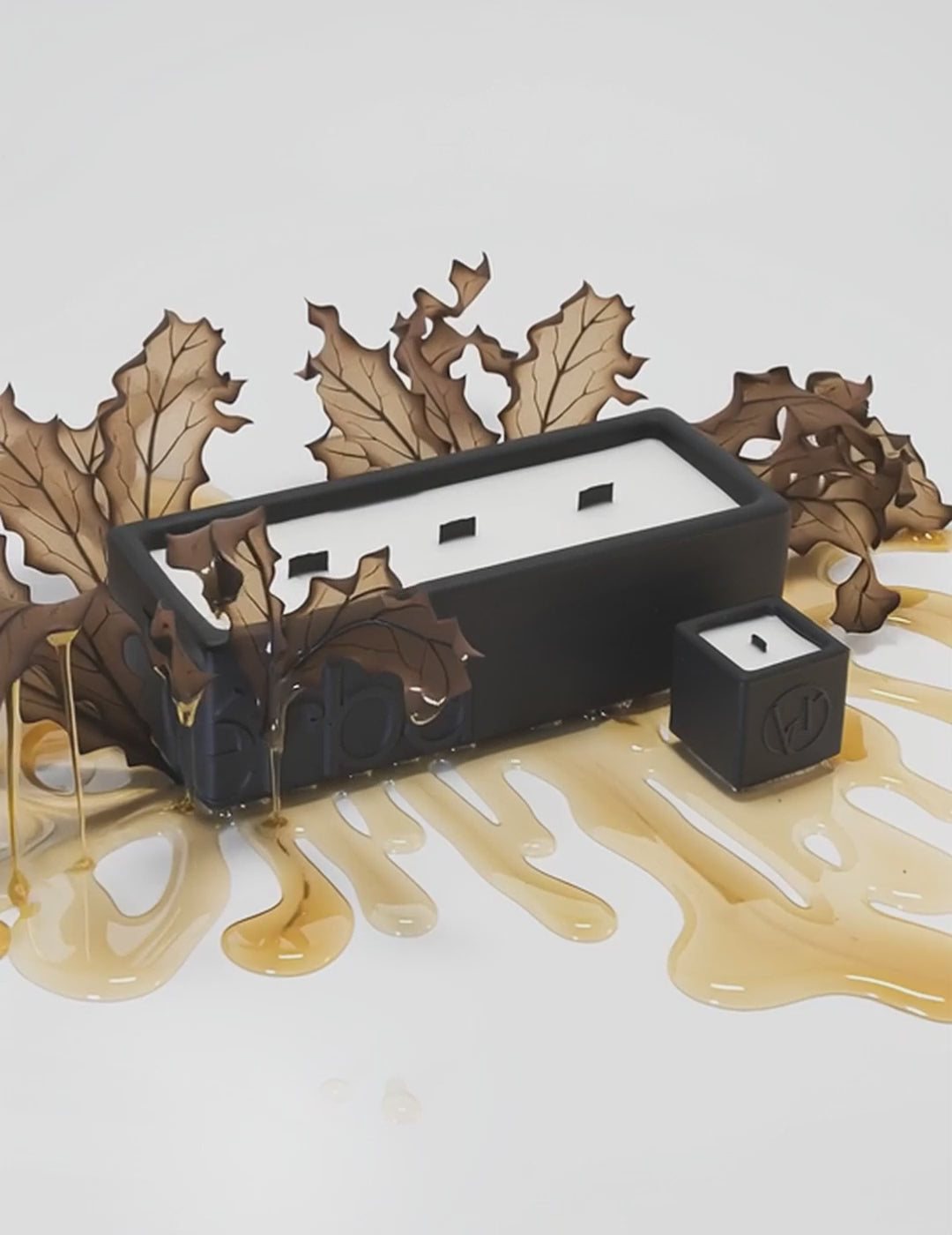 Large black Verba candle surrounded by tobacco leaves and golden honey drips — Sweet Tobacco fragrance video.